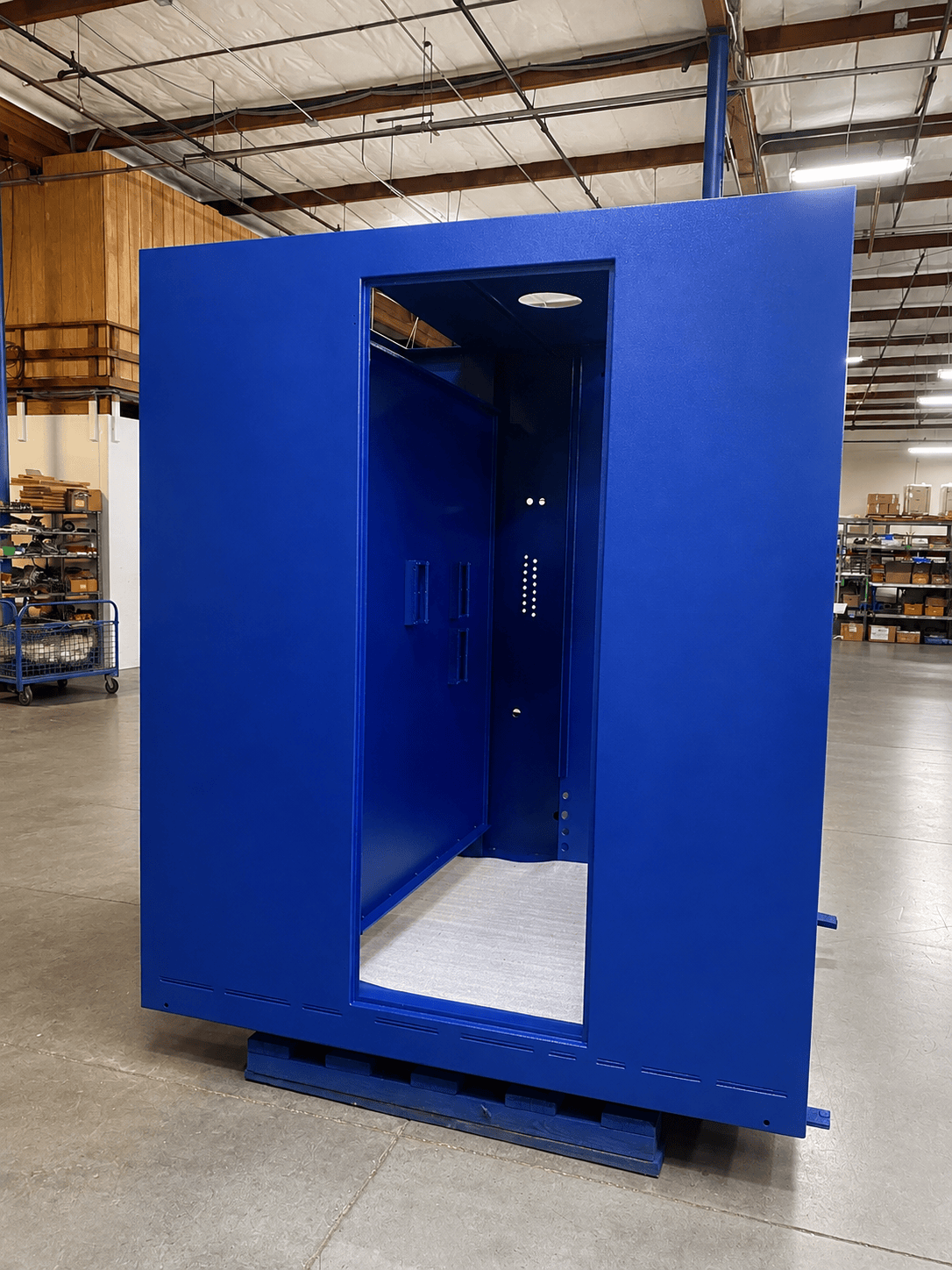 Large blue industrial enclosure inside the Magic Spray facility